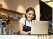 portrait-smiling-asian-barista-cafe-owner-entrepreneur-working-laptop-processing-orders-com